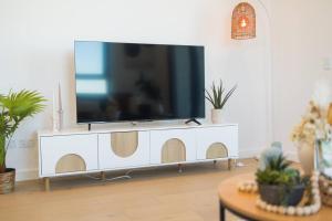 TV en un armario blanco en la sala de estar en Vivid home in Bankstown 2B2B, en Bankstown