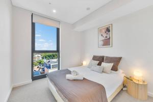 1 dormitorio con cama grande y ventana grande en Vivid home in Bankstown 2B2B, en Bankstown