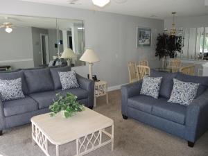 una sala de estar con 2 sofás azules y una mesa. en 1005M condo, en Calabash