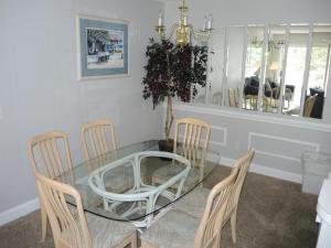a dining room with a glass table and chairs at 1005M condo in Calabash