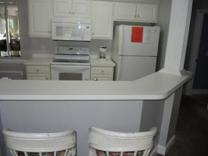 a kitchen with white cabinets and a white refrigerator at 1005M condo in Calabash