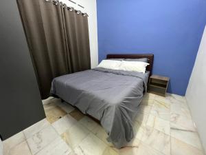 a bed in a room with a blue wall at Near 7ELEVE KFC 10pax 3BR Hutan Melintang by willz in Hutan Melintang