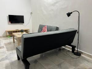 una silla negra en una sala de estar con lámpara en Near 7ELEVE KFC 10pax 3BR Hutan Melintang by willz, en Hutan Melintang