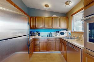 a kitchen with wooden cabinets and a stainless steel refrigerator at Evergreen in Depoe Bay