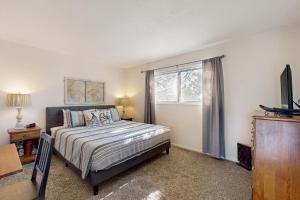 a bedroom with a bed and a tv and a window at Evergreen in Depoe Bay +12 photos