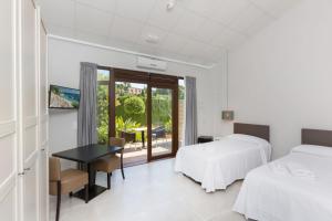 a bedroom with two beds and a desk and a table at Hotel Fortuny javea in Jávea