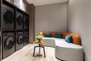 a room with a bed and a washer and dryer at Holiday Inn Express Changfeng Park in Shanghai