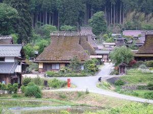 a person riding a bike down a road in a village at Kyoto - House / Vacation STAY 14527 in Kyoto