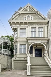 a white house with a gate and a garage at Historic & Charming Victorian Home Sleeps 11 in San Francisco