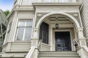 Historic & Charming Victorian Home Sleeps 11 في سان فرانسيسكو: منزل أبيض مع ممر وباب أسود
