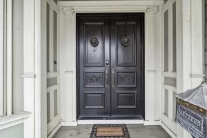 Historic & Charming Victorian Home Sleeps 11 في سان فرانسيسكو: باب أسود للمنزل مع سجادة في الأمام