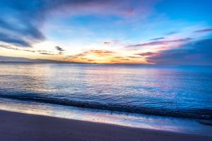 una puesta de sol en la playa con el océano en Radisson Resort & Spa Hua Hin, en Cha Am