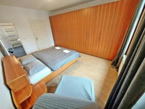 um pequeno quarto com uma cama e uma cadeira em R24, ROSE house em Ljubljana