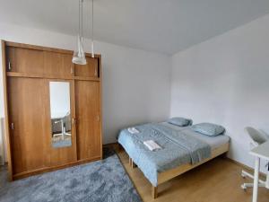 リュブリャナにあるR24, ROSE houseのベッドルーム1室(ベッド1台付)、木製キャビネットが備わります。