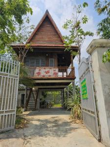 a house with a balcony and a gate at SothAnna Khmer House in Phnom Penh