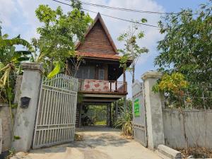 ein Haus mit einem Balkon über einem Tor in der Unterkunft SothAnna Khmer House in Phnom Penh