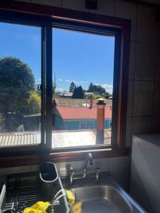 eine Küche mit einem Waschbecken und ein Fenster mit Aussicht in der Unterkunft Departamento en Pitrufquén in Pitrufquén