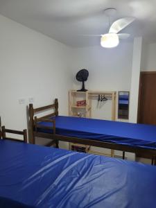 a room with a bed and a ceiling fan at Casa nova em Caraguatatuba in Caraguatatuba