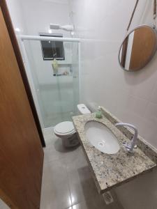 a bathroom with a sink and a toilet at Casa nova em Caraguatatuba in Caraguatatuba +24 photos
