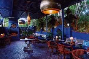 a restaurant with tables and chairs and plants at Villa Royale in Palm Springs