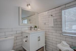 a white bathroom with a sink and a mirror at Cozy 1BR Dine Play & Sip in Urban Mtn Paradise in Colorado Springs
