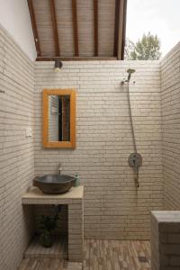 a bathroom with a sink and a brick wall at Villa Rika in Gili Trawangan