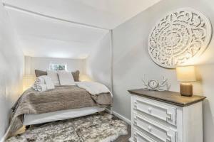 a bedroom with a bed and a dresser and a mirror at 1BR Woodland Hideaway - Downtown and Hiking Nearby in Woodland Park