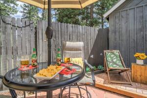 a patio with a glass table with food and drinks at 1BR Woodland Hideaway - Downtown and Hiking Nearby in Woodland Park