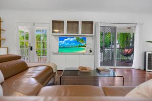 Tropical Refuge في Stratford: غرفة معيشة مع أريكة وتلفزيون