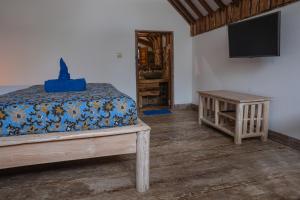 a bedroom with a bed and a flat screen tv at Villa Rika in Gili Trawangan