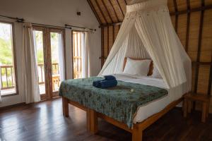 a bedroom with a bed with a bag on it at Villa Rika in Gili Trawangan
