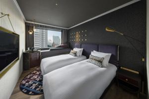 東京にあるメルキュール 東京日比谷のベッド2台とテレビが備わるホテルルームです。
