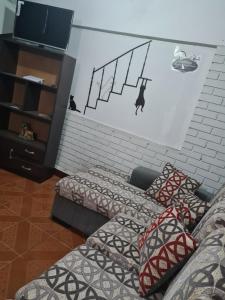 a living room with two beds and a wall with a mural at Zeus cómodo e Imperdible in Cochabamba