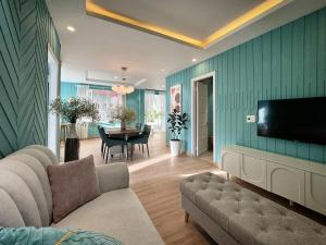 a living room with a couch and a flat screen tv at Your Second Home - Garden House in center of Dalat in Da Lat