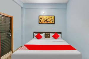 a bedroom with a bed with red pillows on it at Flagship Rk Residency Near Iskcon Temple Noida in Noida