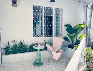 a patio with a table and a chair and some plants at Your Second Home - Garden House in center of Dalat in Da Lat