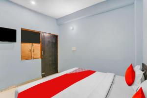 a bedroom with a bed with red pillows at Flagship Rk Residency Near Iskcon Temple Noida in Noida