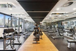 a gym with a lot of treadmills and machines at Chic 2-Bed with Skyline Views Pool and Gym in Brisbane