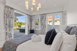 a bedroom with a bed and a large window at Hampton on View Luxury Clifftop in Campbells Bay in Auckland +46 photos