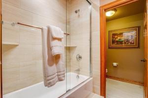 科罗拉多斯普林斯Fox Run Lux Private Suite Nature Views Aplus Spot的一间带浴缸和淋浴的浴室,配有玻璃门