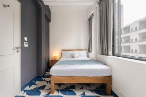 una piccola camera con letto e finestra di Habyt Bridges Collection a Hong Kong