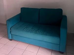 un sofá azul sentado en la esquina de una habitación en Studio Piratas, en Angra dos Reis