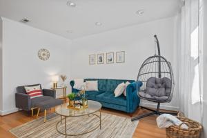sala de estar con sofá azul y silla en Luxury 2bd Haven in DC's Heart!, en Washington