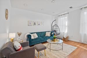 sala de estar con sofá azul y mesa en Luxury 2bd Haven in DC's Heart!, en Washington