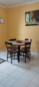 a dining room table with chairs and a clock on the wall at Casa das Pedras Altas in Lajes do Pico