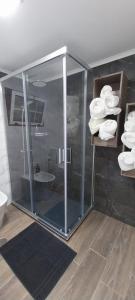 uma cabina de duche em vidro na casa de banho com toalhas em Casa das Pedras Altas em Lajes do Pico