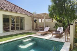 een achtertuin met een zwembad en een huis bij Villa Puri Pura in Canggu