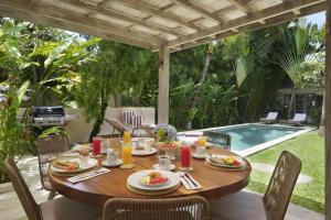 een tafel met borden eten op een patio met een zwembad bij Villa Puri Pura in Canggu