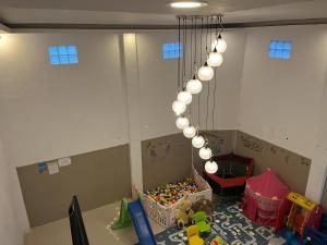 Habitación con mesa con juguetes y lámpara de araña. en Rayana Resort Mitra Reddoorz, en Songgoriti