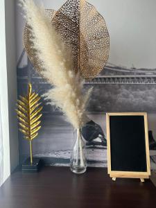 un vase avec des plumes sur une table à côté d'une photo dans l'établissement SMDC FORT TAGAYTAY STAYCATION, à Kaybagal